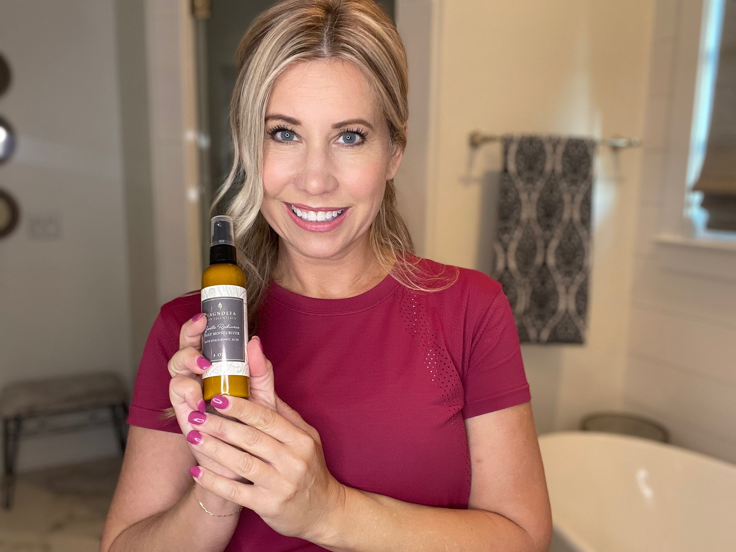 Smiling woman holding a bottle of Gentle Radiance Daily Moisturizer