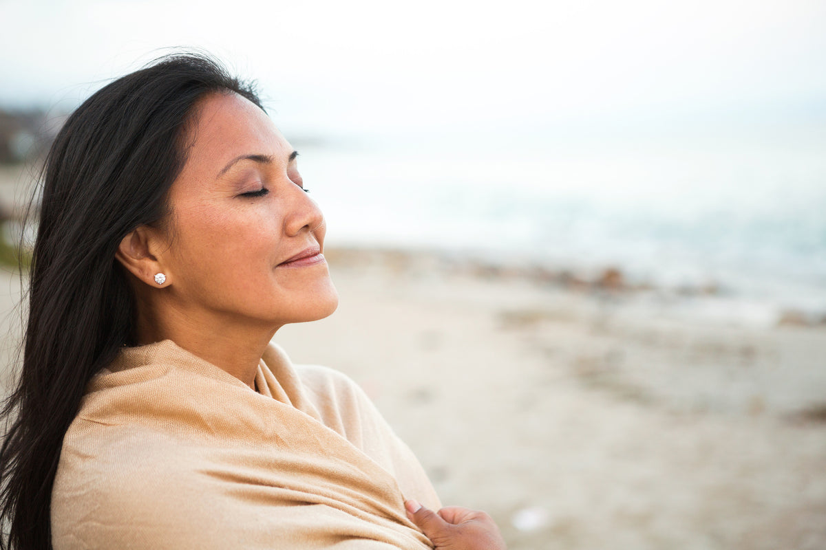 Woman with eyes closed enjoying the breeze on a beach
