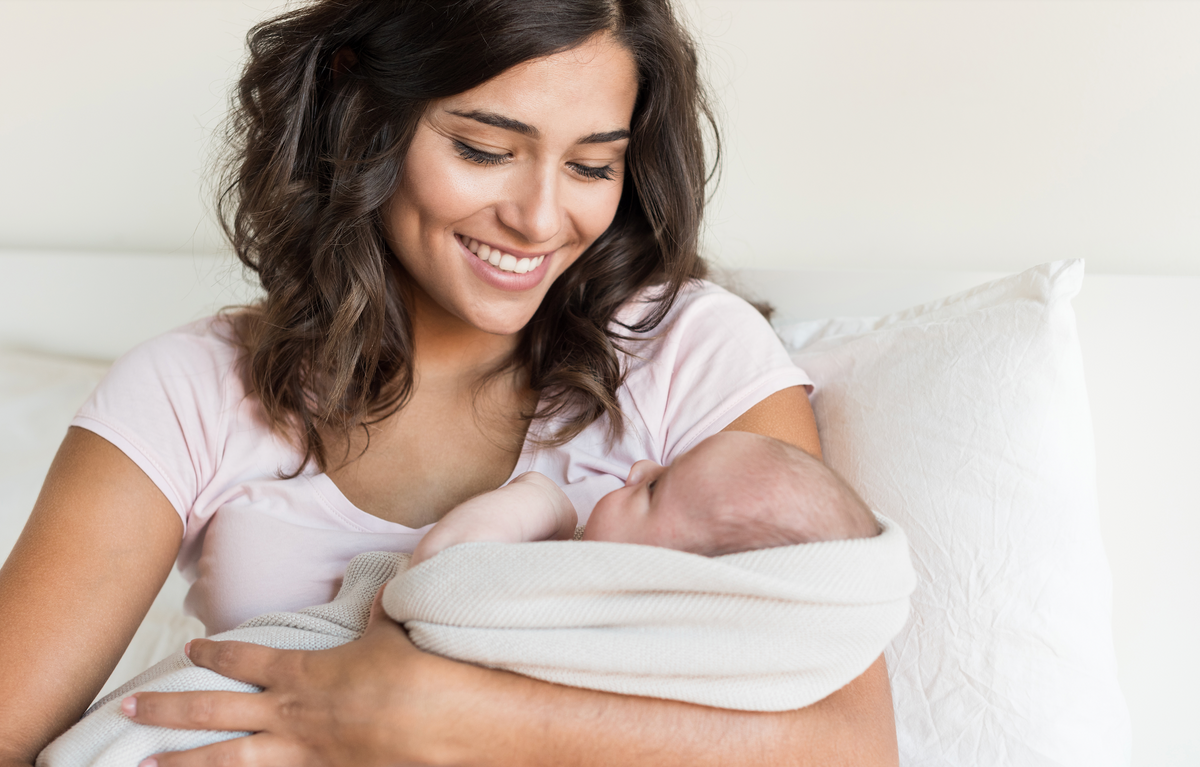 Smiling mother holding her newborn baby