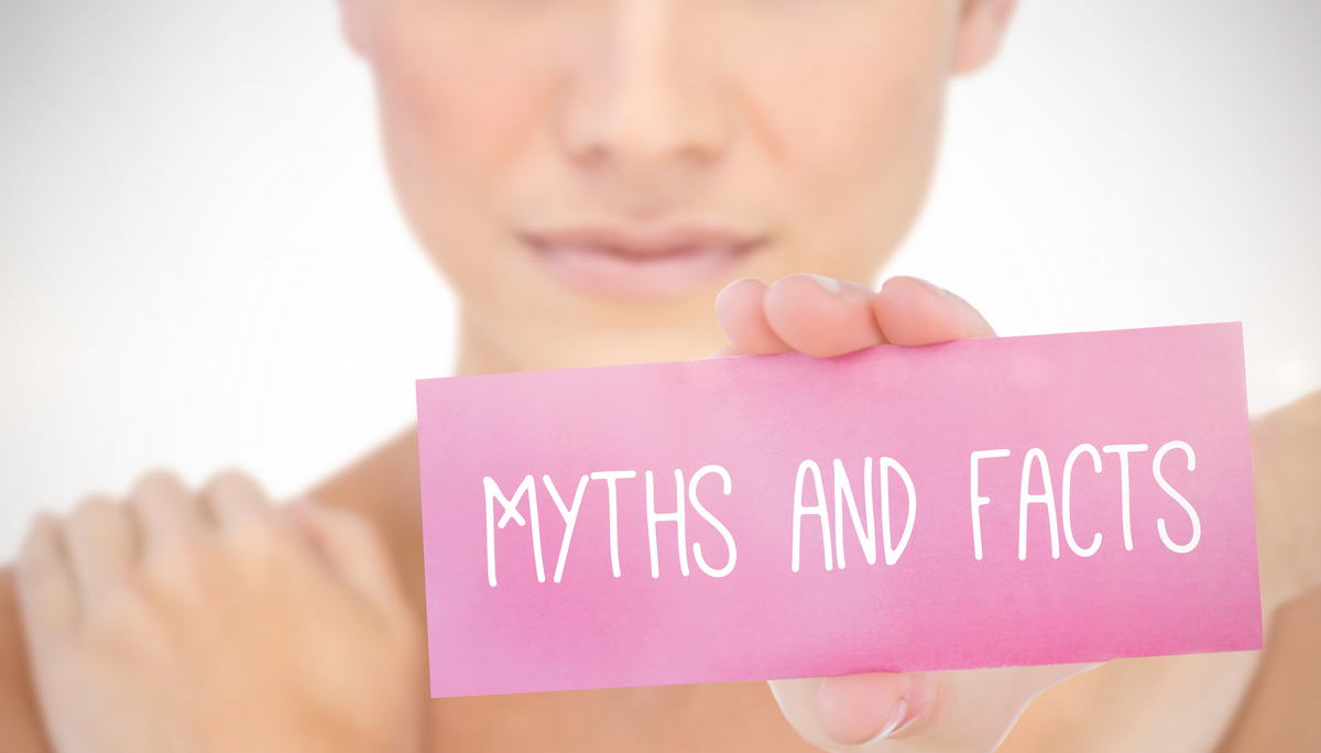 Woman holding a pink card reading 'Myths and Facts'