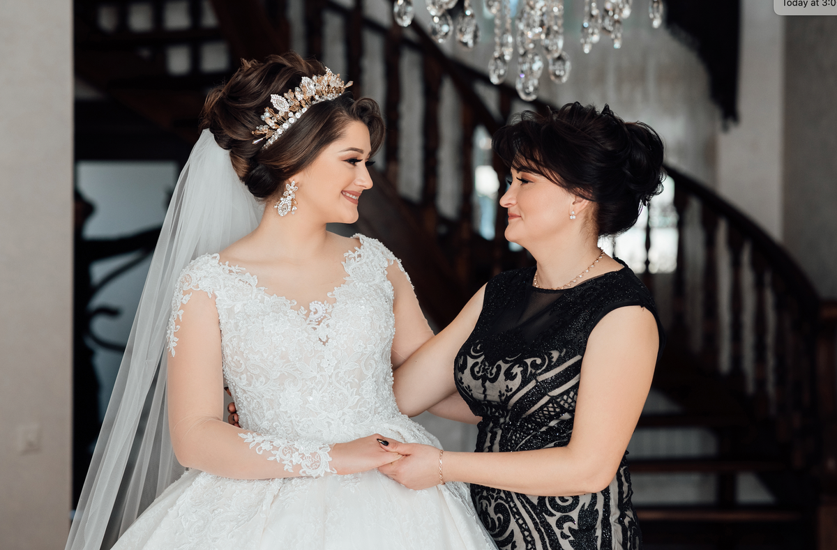 Mother of the bride smiling with her daughter in a wedding gown