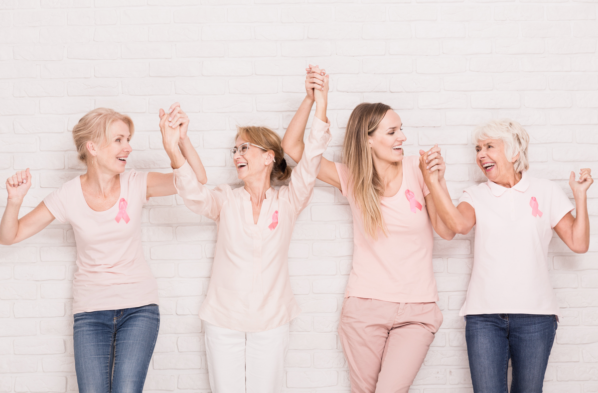 Group of joyful women holding hands and celebrating