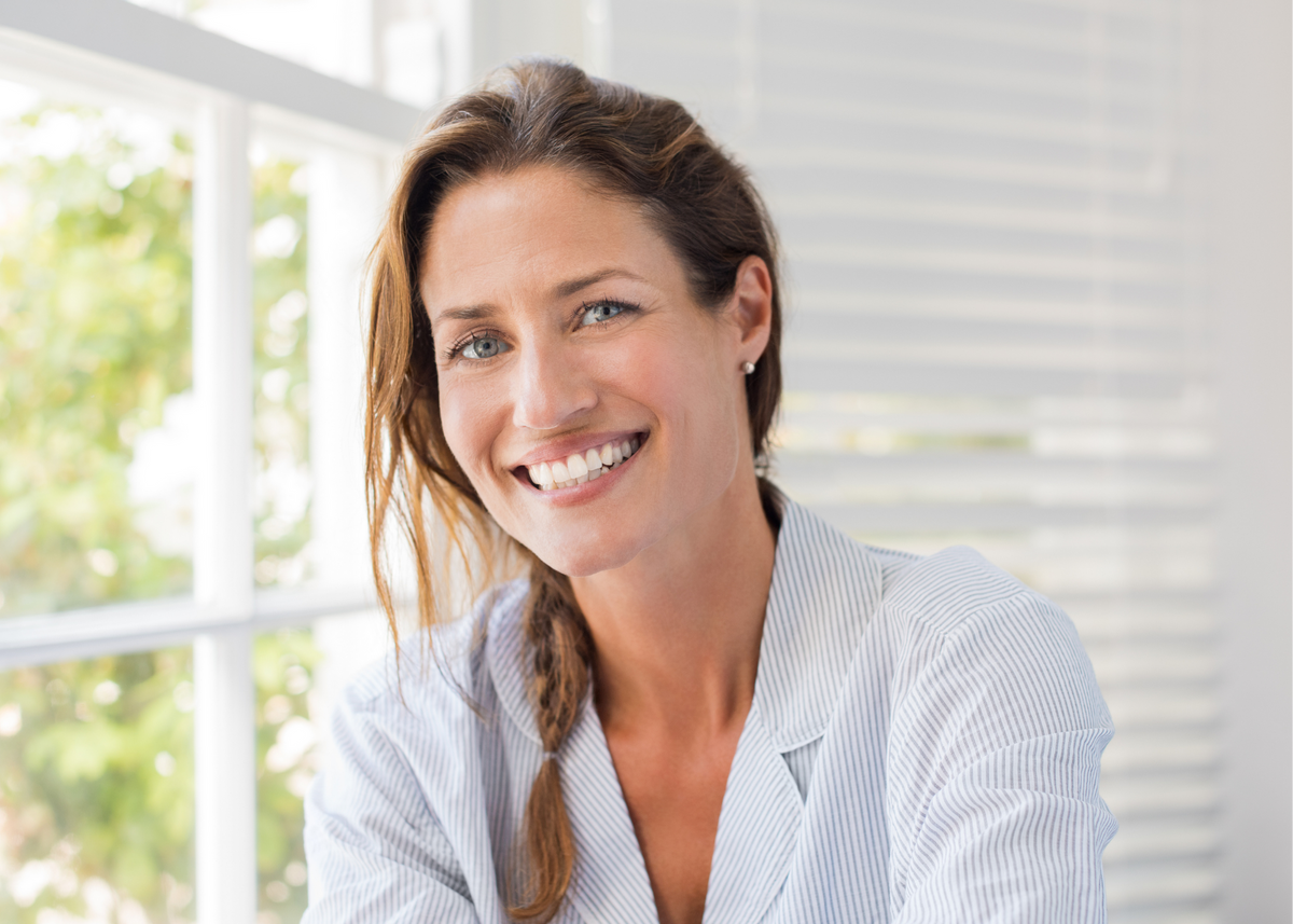 Smiling woman in a white blouse in a bright room