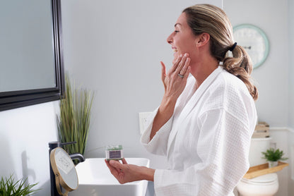 Woman massaging Magnolia Jojoba Brightening Face Scrub onto her face