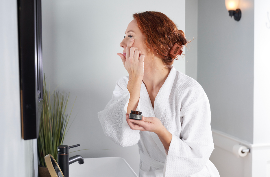 Woman gently applying Vitamin Boost Eye Repair Cream under her eyes